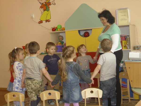 Дети и педагог стоят в кругу, держась за руки