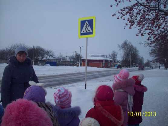 Дети и воспитатель наблюдают за пешеходным переходом и проезжей частью