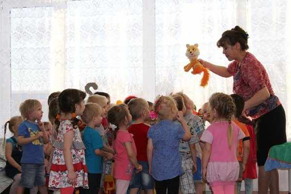 Воспитательница показывает детям игрушку-лисичку