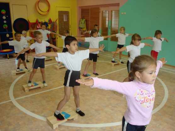 Дети выполняют упражнение на физкультуре