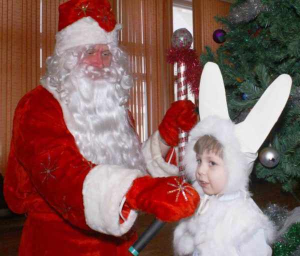 Мальчик в костюме зайчика рассказывает стихотворение Деду Морозу