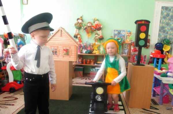 Мальчик в форме инспектора ДПС и девочка разыгрывают ситуацию на дороге