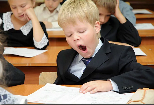 Мальчик зевает на уроке
