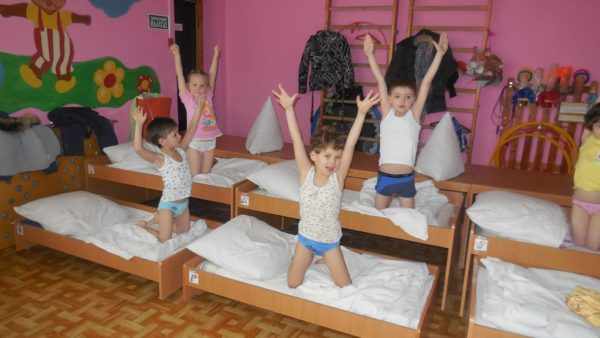 Дети делают гимнастику после сна в кроватях