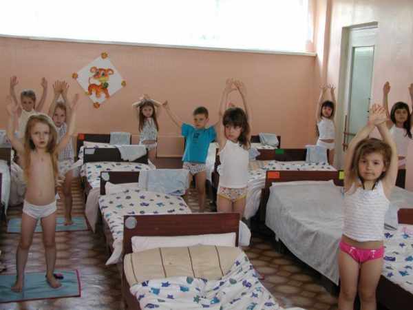 Дети стоят с поднятыми руками у кроватей