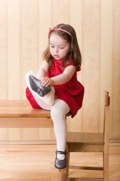 Девочка сама надевает туфли