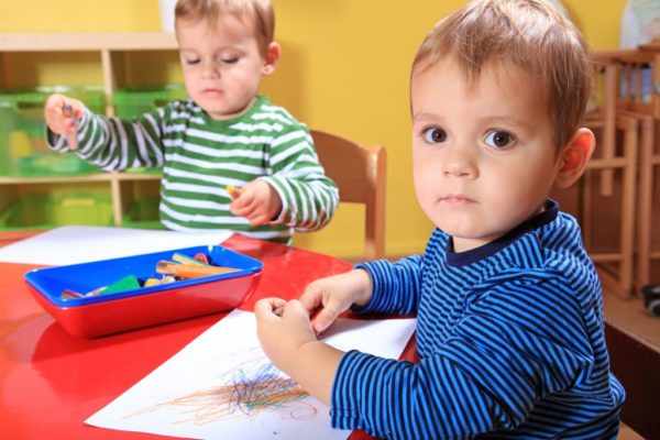 Два мальчика рисуют карандашами