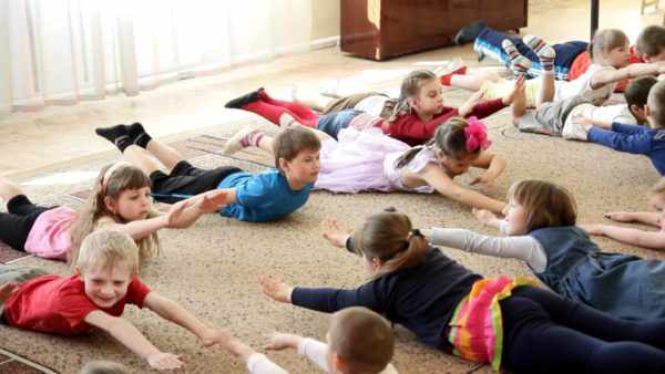 Дети выполняют упражнение в положении лёжа