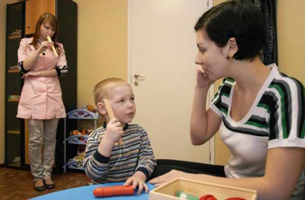 Мальчик и педагоги занимаются улучшением слуха