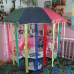 Пляжный зонт с длинными лентами, установленный на маленьком столике