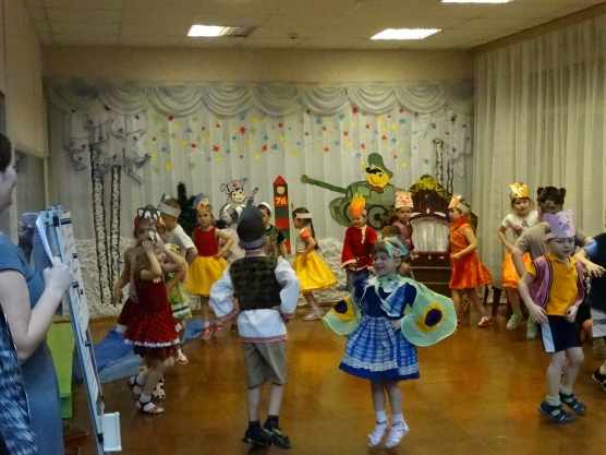 Дети в костюмах танцуют в зале