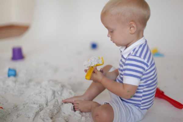 Малыш играет с кинетическим песком