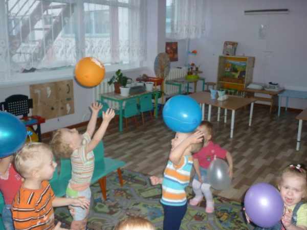 Дети в группе играют воздушными шарами
