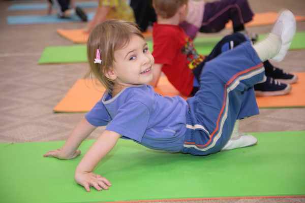 Дети выполняют упражнение на ковриках