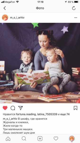 Мама читает двум малышам, сидящим у неё на коленях