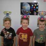 Трое ребят в самодельных шлемах космонавтов