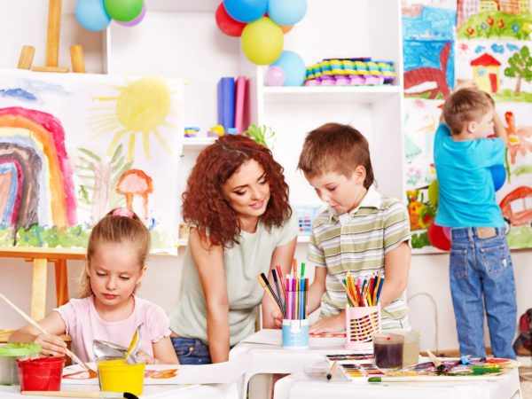 Дети рисуют, педагог помогает