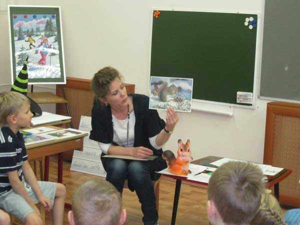 Воспитатель показывает детям картинки с изображением зимы