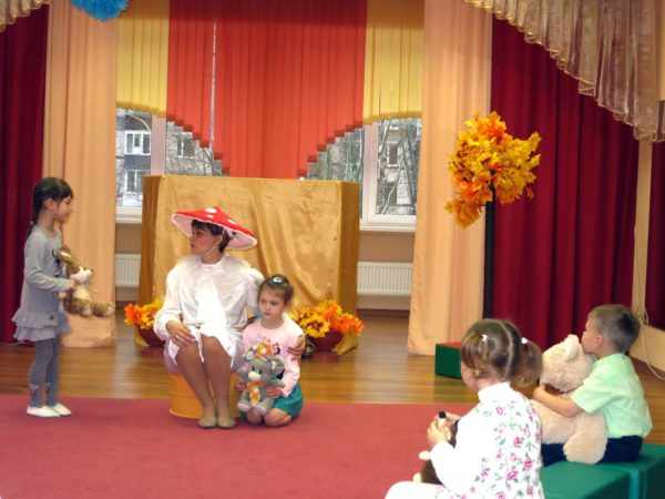 Воспитательница в костюме мухомора, дети в игрушками в руках возле неё