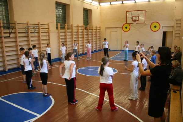 Школьники играют в подвижную игру в спортивном зале