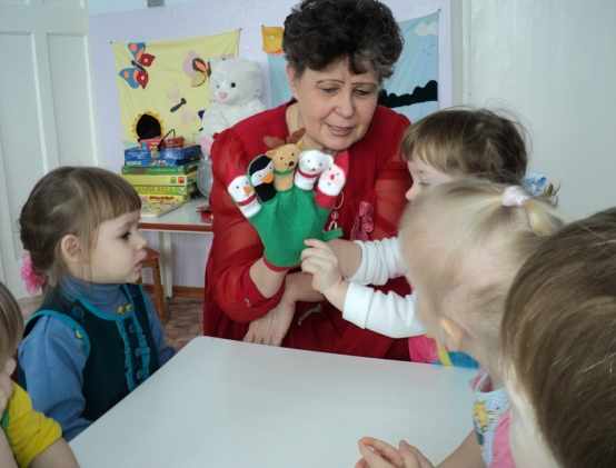 Воспитатель показывает детям кукол на перчатке