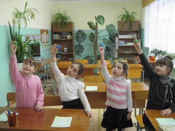 Четыре девочки делают зрительную гимнастику с шариками в руках