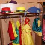 Уголок ряжения: стеллаж с перекладиной под вешалку для костюмов и полкой под красную и жёлтую шляпы