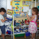 Мальчик и девочка рассматривают материалы в исследовательском уголке