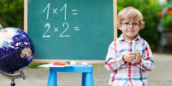 Мальчик стоит у доски с математическими примерами