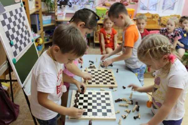 Дети расставляют фигуры на шахматных досках