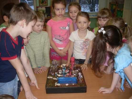Группа детей изучает макет вулкана