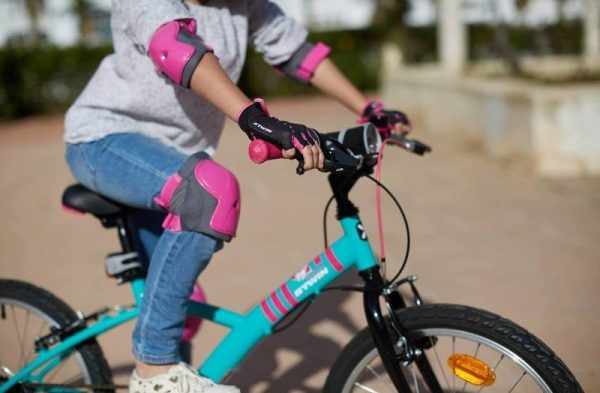 Ребёнок на велосипеде в налокотниках и наколенниках