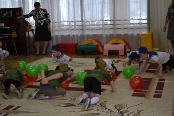 Дети ползут по полу в игре с мячами