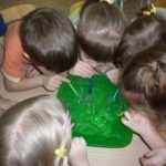 Дети дуют из трубочек в зелёный таз с мыльной водой