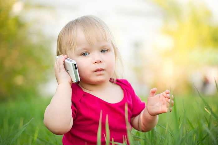 Маленька девочка говорит по мобильному телефону
