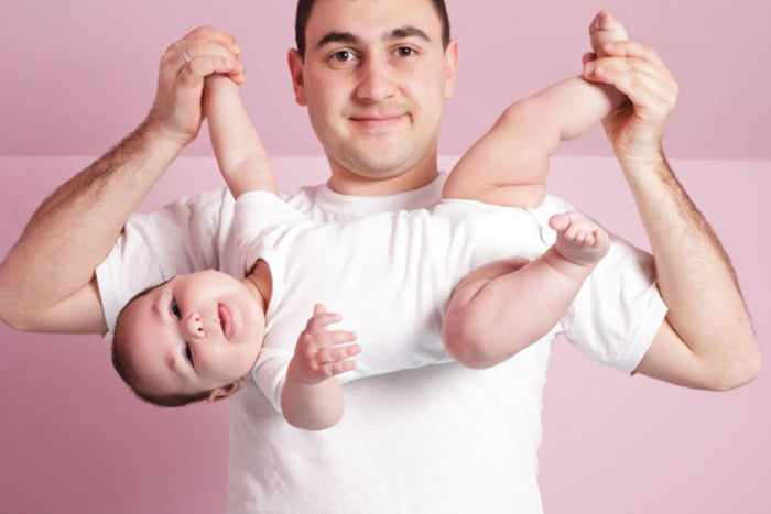 Мужчина занимается динамической гимнастикой с ребенком