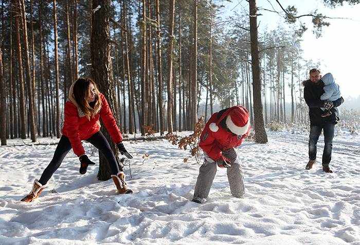 Родители с детьми играют в снежки