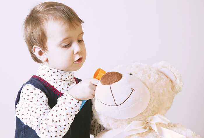Ребенок играет с игрушечным медведем