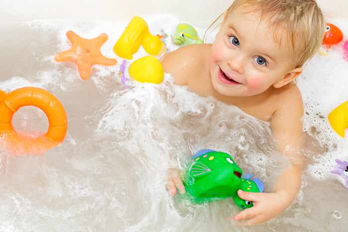 Ребенок с игрушками в ванне
