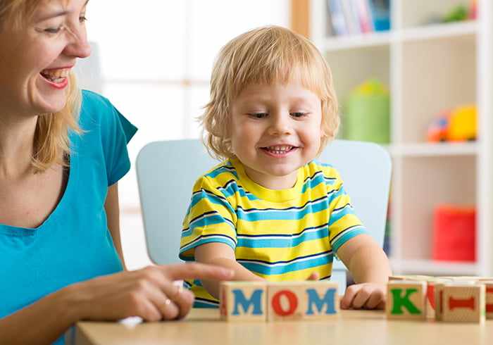 Ребенок играет в кубики с английскими буквами