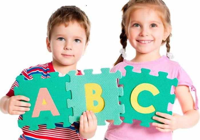 Дети держат пазлы с английскими буквами