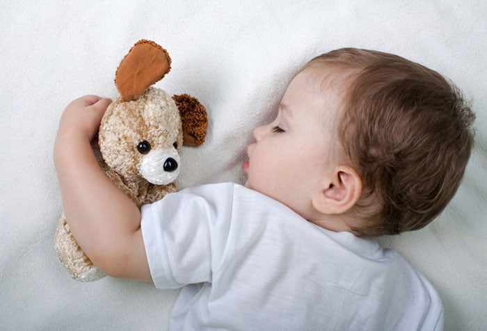 Малыш спит с игрушкой