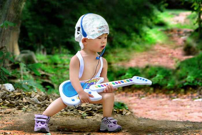 Ребенок с игрушечной гитарой