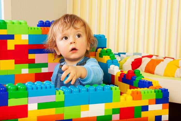 Ребенок строит стены из конструктора
