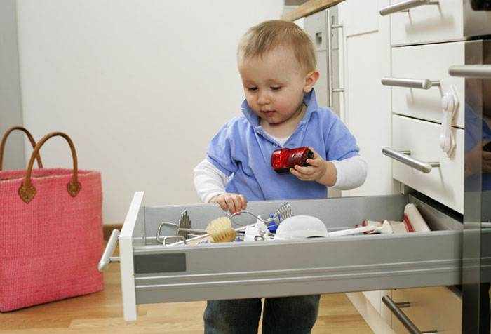 Ребенок копается в ящике на кухне