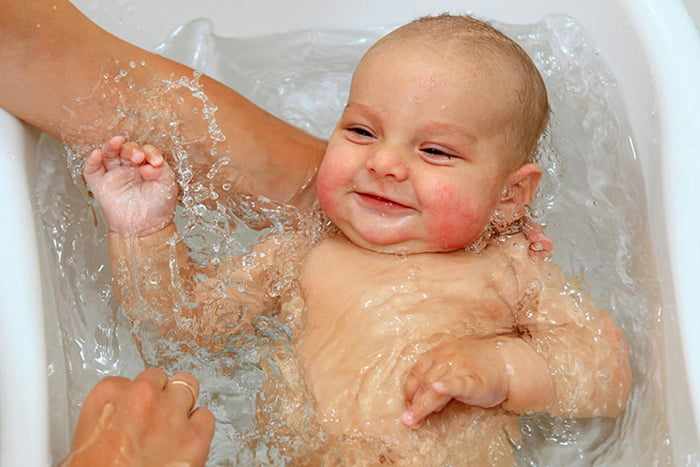 Довольный малыш во время купания
