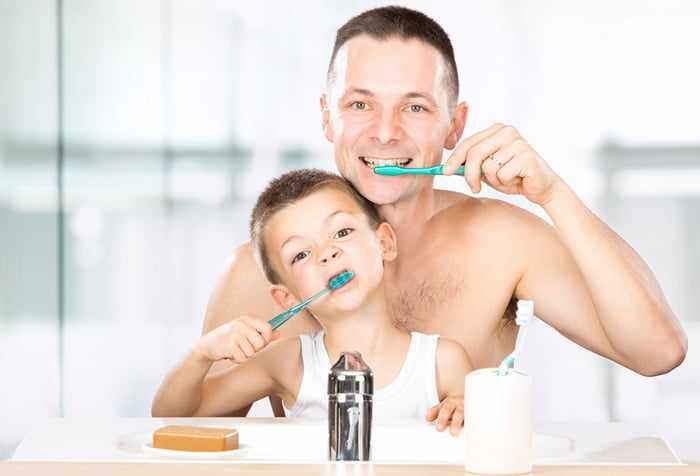 Мальчик с папой чистят зубы