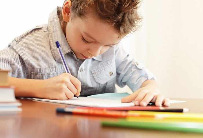 Мальчик пишет в тетради