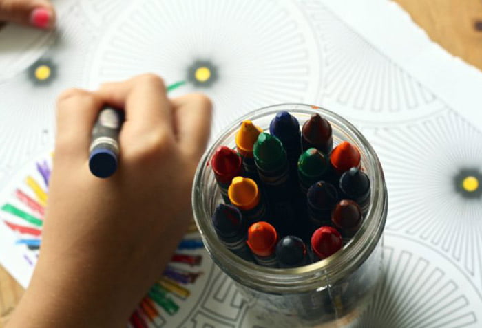 Ребенок рисует восковыми мелками