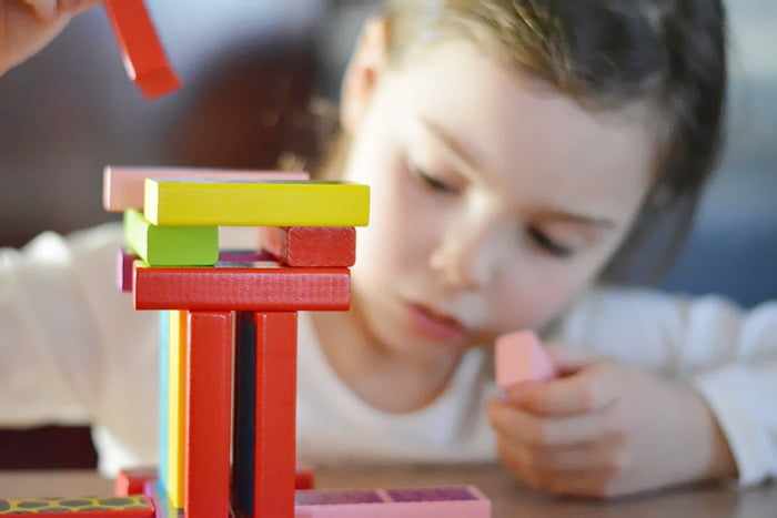Ребенок строит башню из конструктора